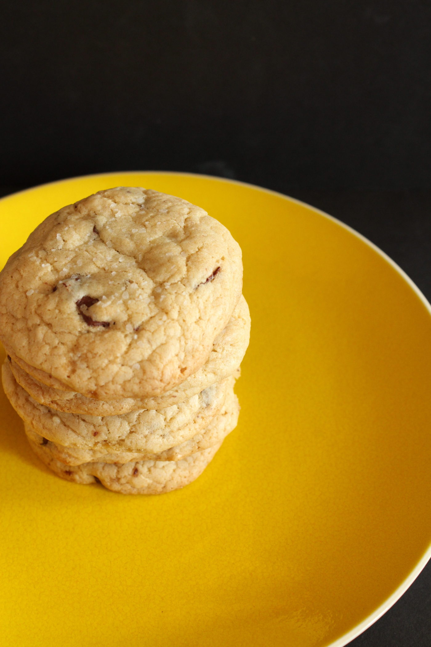 Chocolate chip cookies stacked on yellow plate